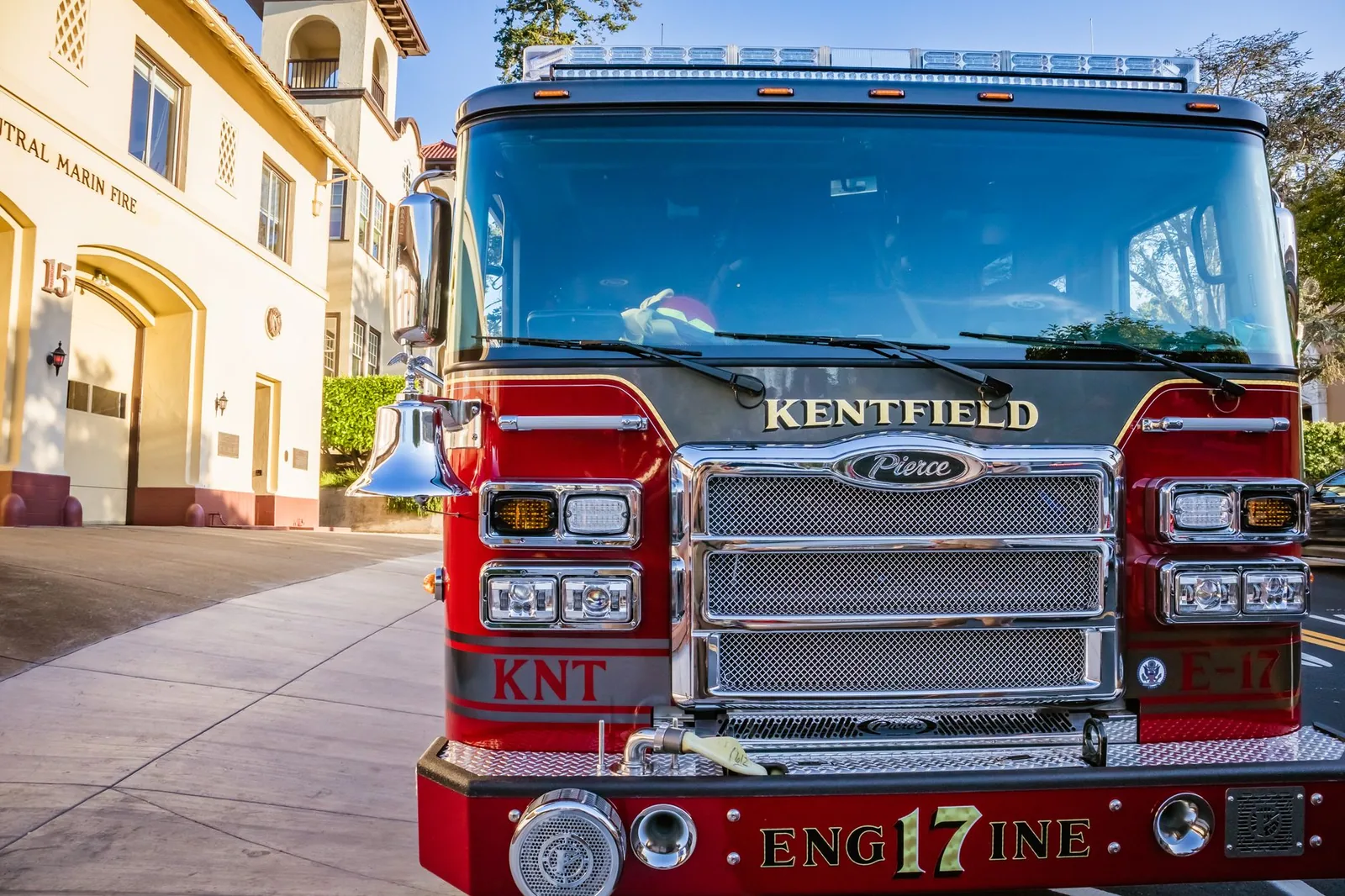 A red fire truck parked in front of a fire station.