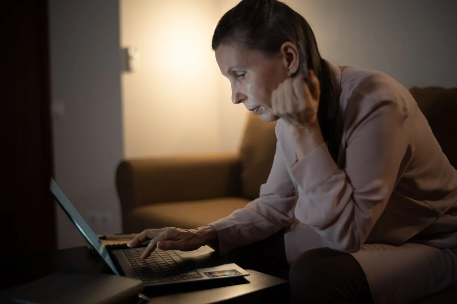 Woman looking at a laptop screen on a coffee table