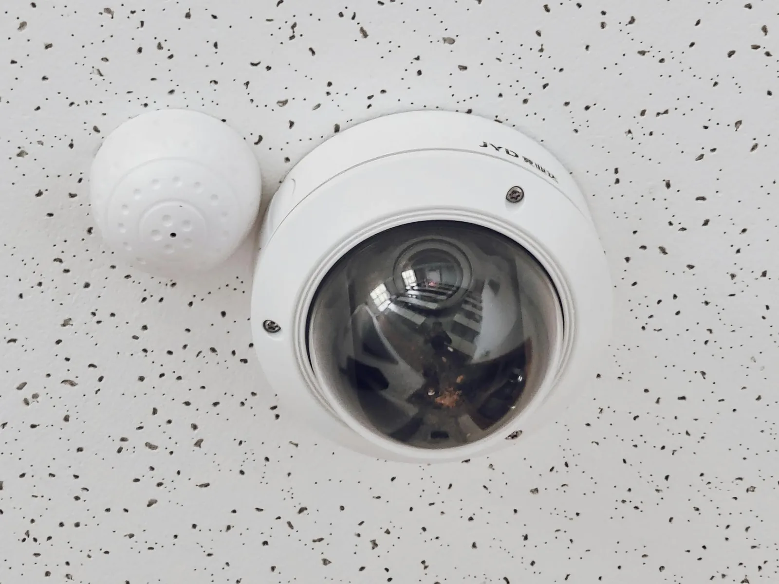 A round dome surveillance camera mounted on a ceiling.